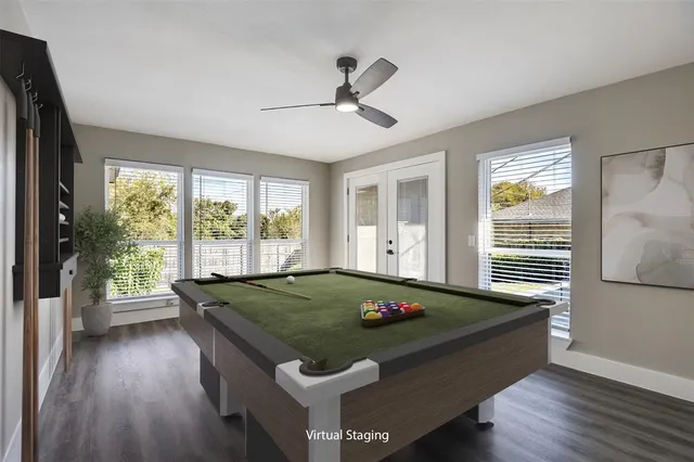 a room with pool table and windows