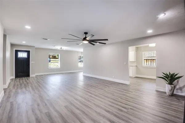 a view of a livingroom with wooden floor and a ceiling fan