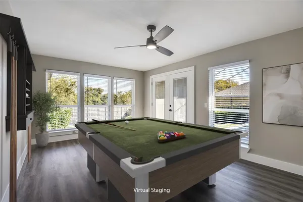 a room with pool table and windows
