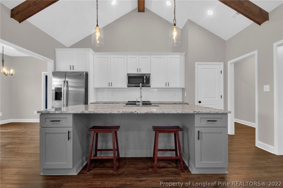 171 Mumford Road Raeford, NC 28376 - Photo 11 of 35 a kitchen with stainless steel appliances granite countertop a sink a stove a refrigerator and island with wooden floor