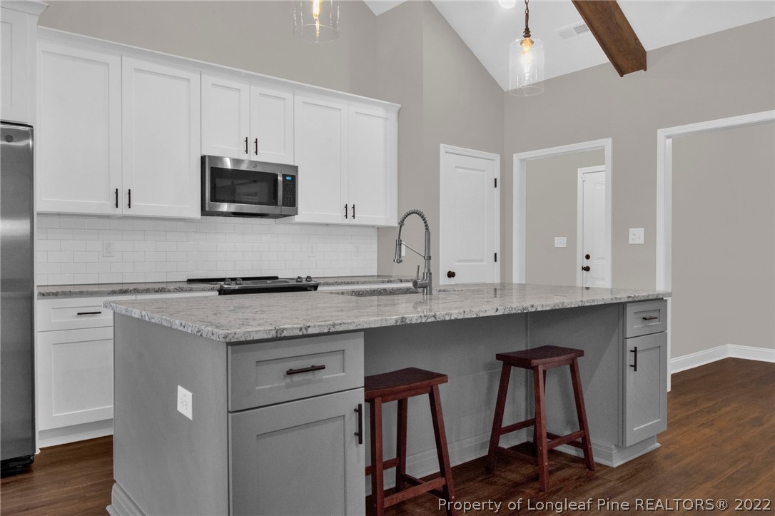 171 Mumford Road Raeford, NC 28376 - Photo 12 of 35 a kitchen with stainless steel appliances granite countertop a stove top oven microwave and cabinets