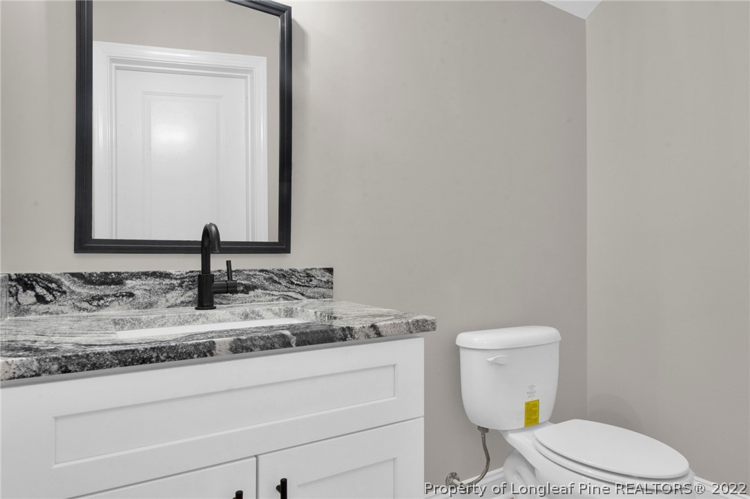 171 Mumford Road Raeford, NC 28376 - Photo 32 of 35 a bathroom with a granite countertop toilet sink and mirror