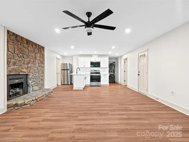 a view of room with window ceiling fan and wooden floor