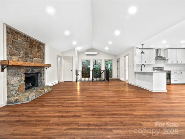 a view of empty room with wooden floor and fireplace