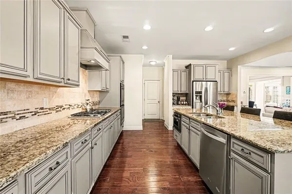 a large kitchen with stainless steel appliances granite countertop a lot of counter space and a sink