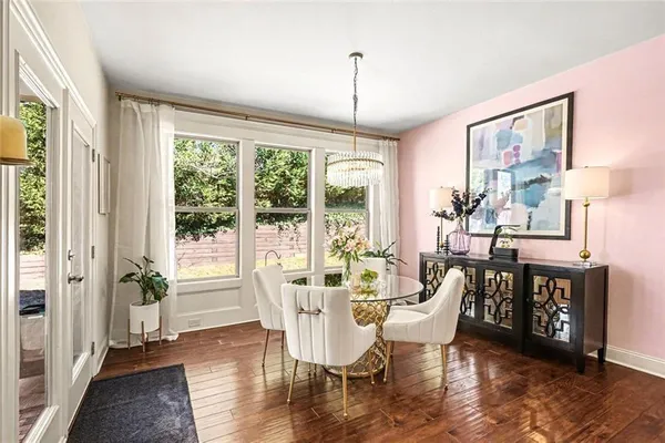 a dining room with furniture a chandelier and wooden floor
