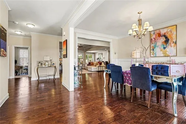a view of a dining room and livingroom with furniture wooden floor a chandelier