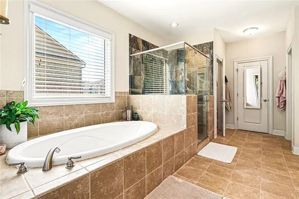 a bathroom with a tub a sink and a large mirror