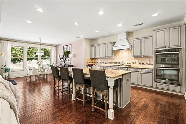 a kitchen with a table chairs microwave and cabinets