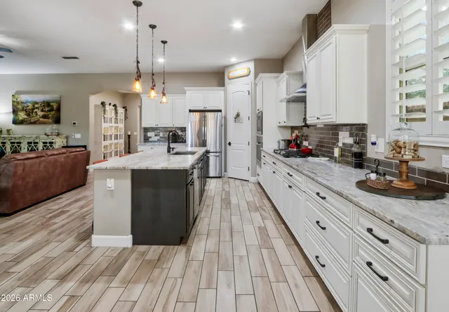 a kitchen with stainless steel appliances white cabinets and a stove top oven
