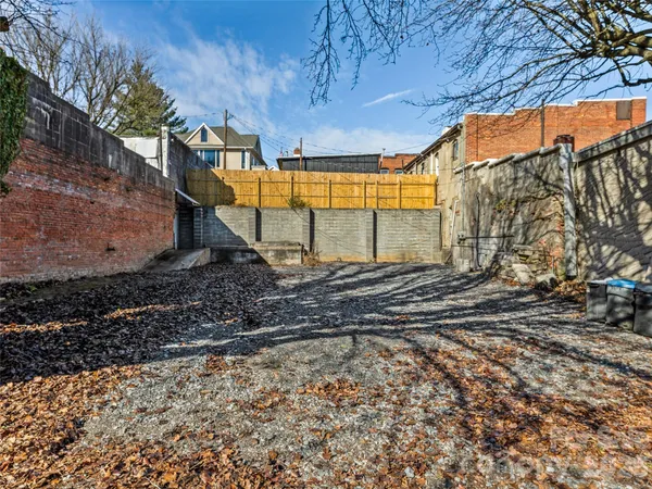 a view of a hallway with wooden floor and a living room