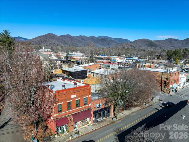 an aerial view of residential houses with outdoor space and parking
