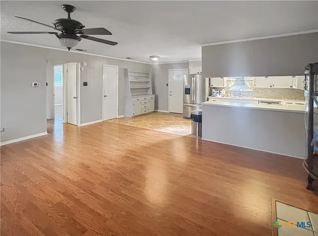 a view of kitchen with wooden floor cabinets and a refrigerator