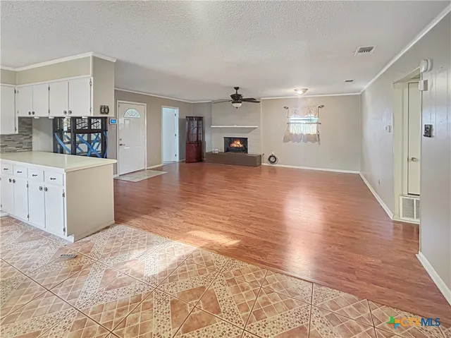 a view of empty room with wooden floor and fireplace