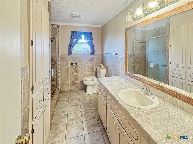 a en suite bathroom with a granite countertop sink and a mirror