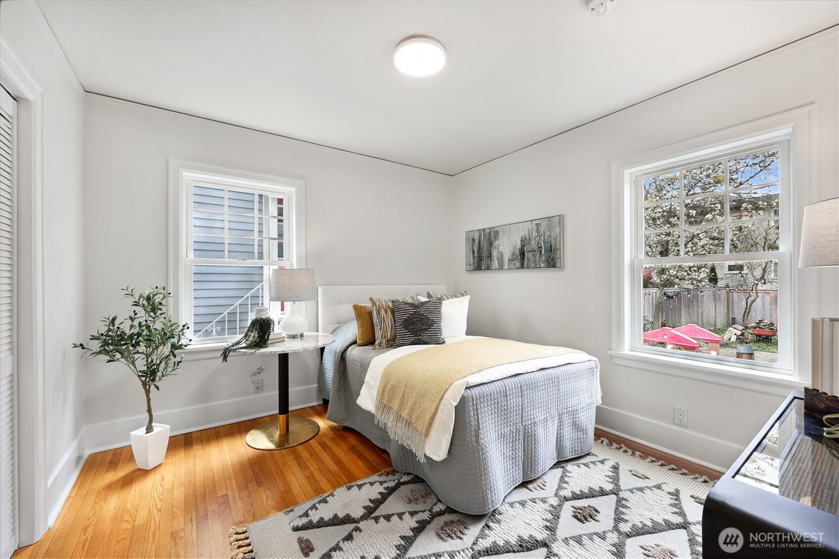 8401 Linden Avenue North Seattle, WA 98103 - Photo 18 of 36 a bedroom with a bed and wooden floor