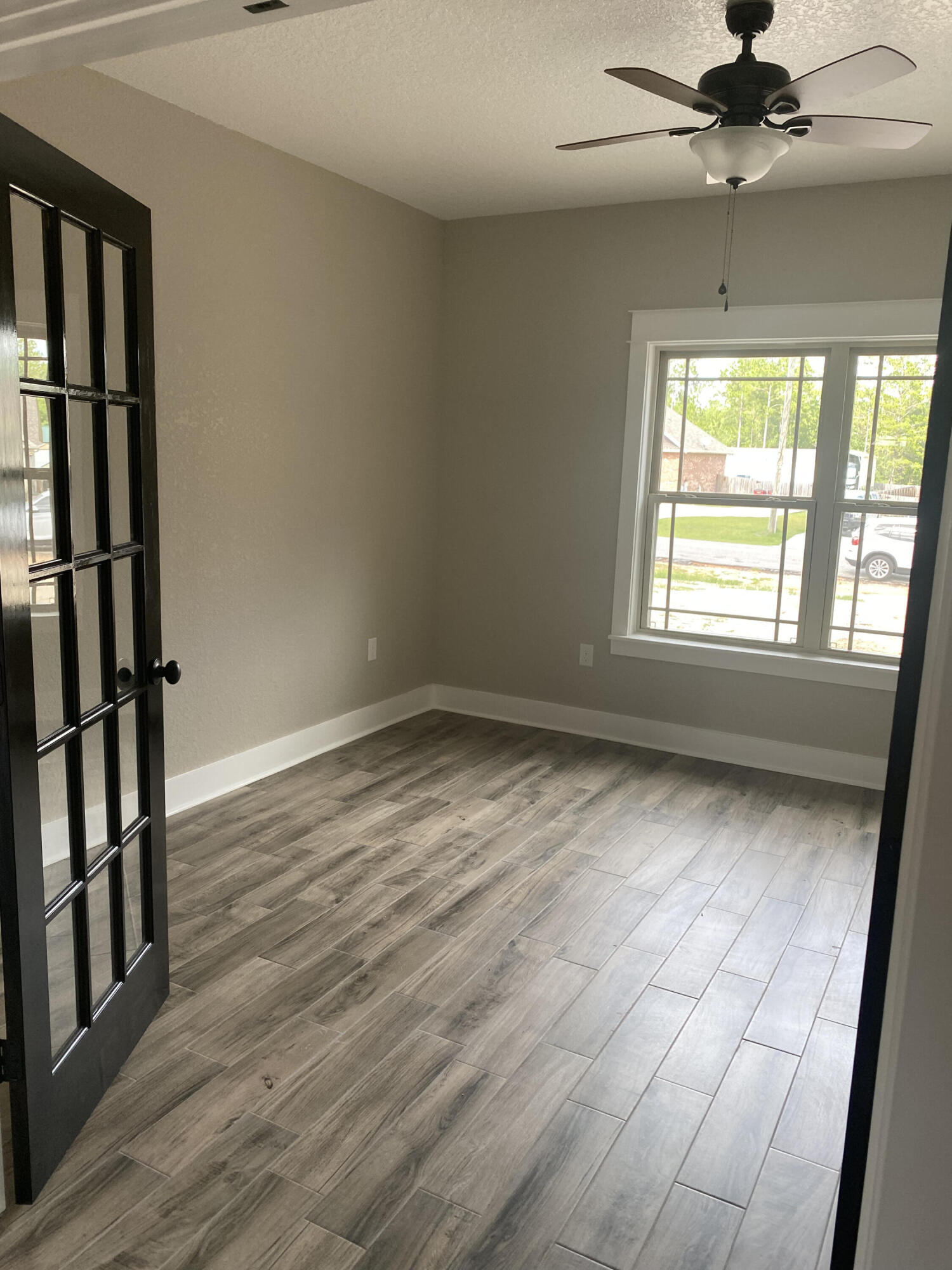 4085 Happy Trails Road Crestview, FL 32539 - Photo 8 of 19 a view of an empty room with wooden floor and a window