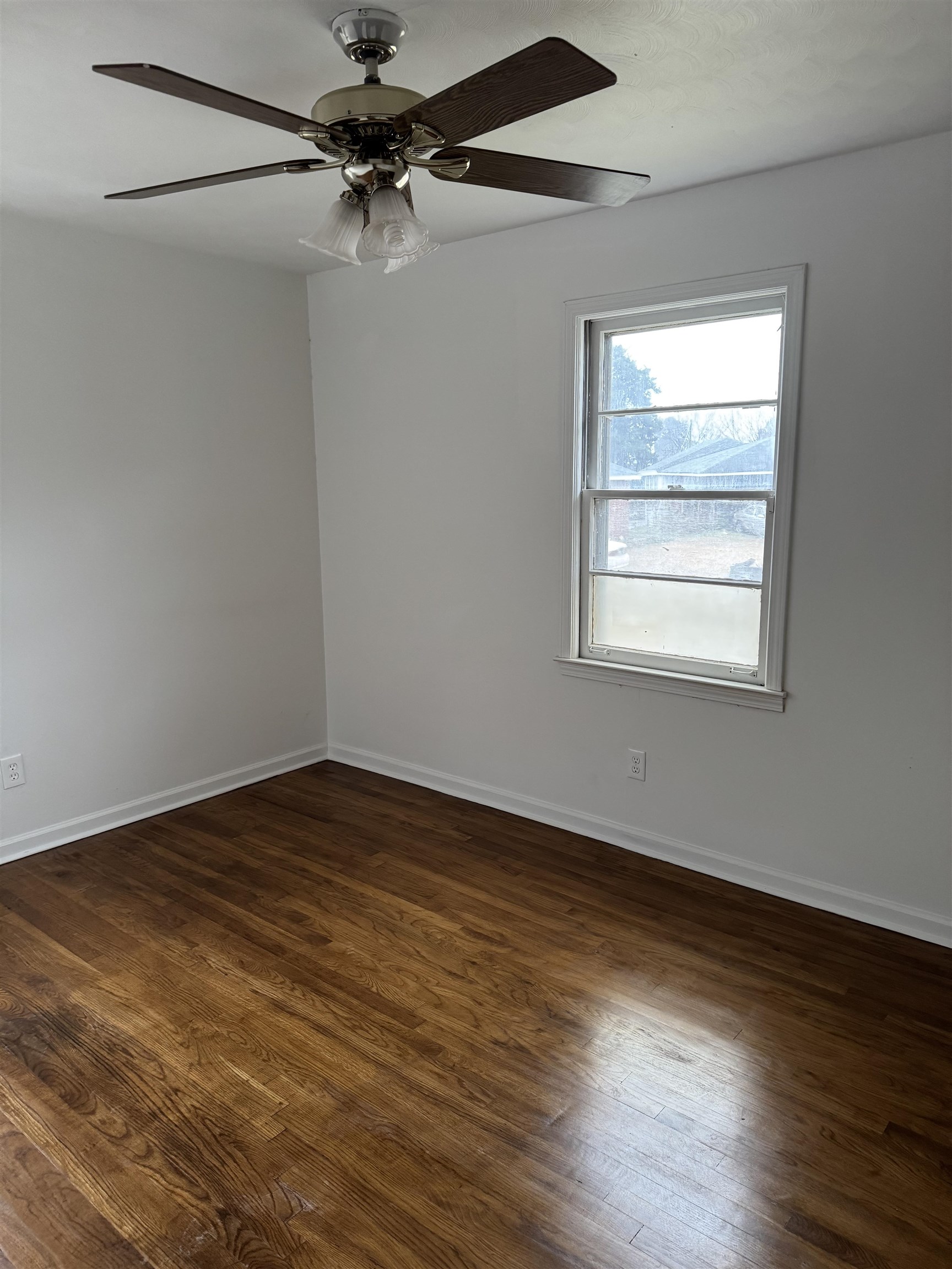 2404 Perry Cove Memphis, TN 38106 - Photo 6 of 8 a view of an empty room with a window and wooden floor