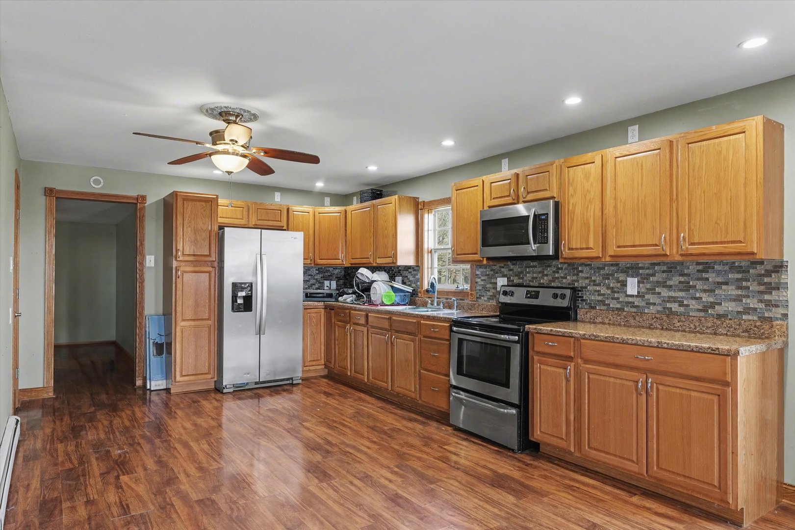 110 Highway 54 Roberts, IL 60962 - Photo 9 of 31 a kitchen with stainless steel appliances granite countertop a refrigerator a stove top oven a sink and dishwasher with wooden floor