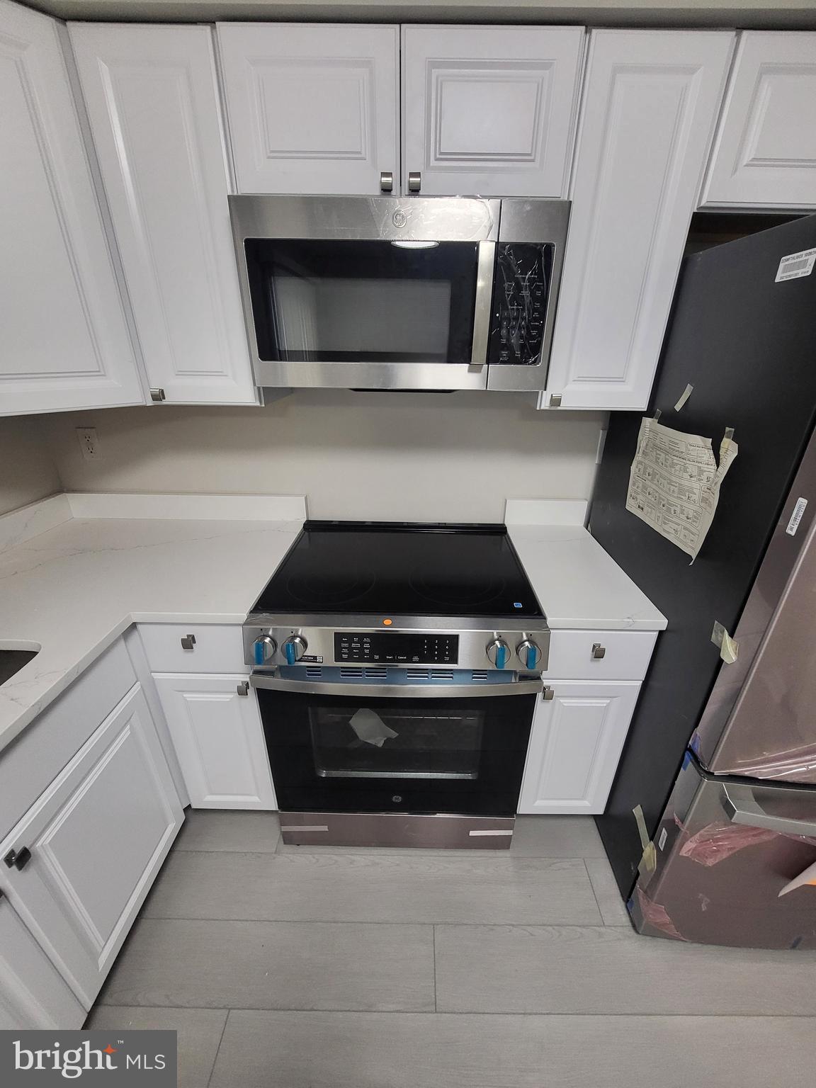 3203 Prince Ranier Place District Heights, MD 20747 - Photo 7 of 18 a kitchen with granite countertop a stove and a microwave