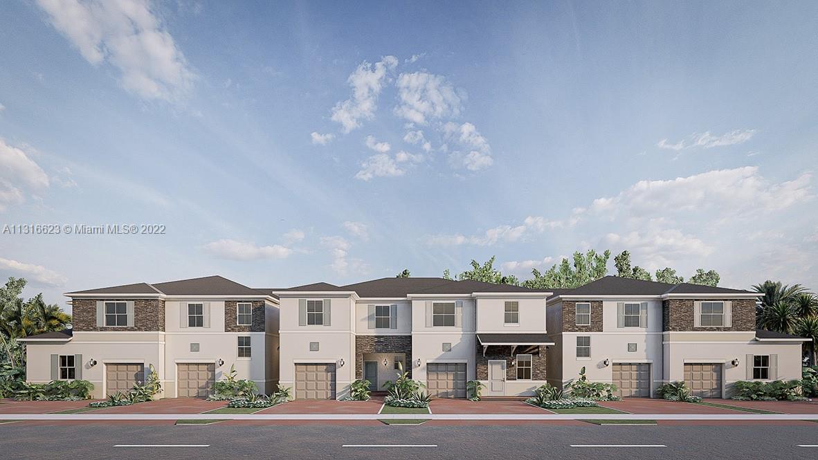 a front view of residential houses with yard and parking space