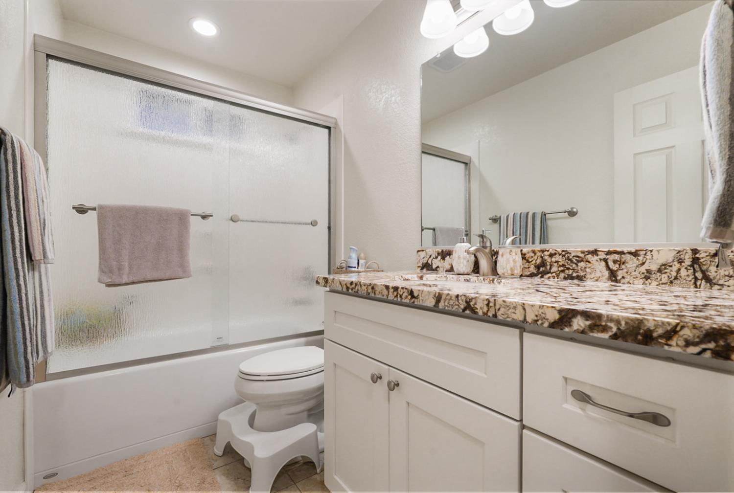 1820 North Berkeley Avenue Turlock, CA 95382 - Photo 20 of 29 a bathroom with a granite countertop sink a toilet and a mirror