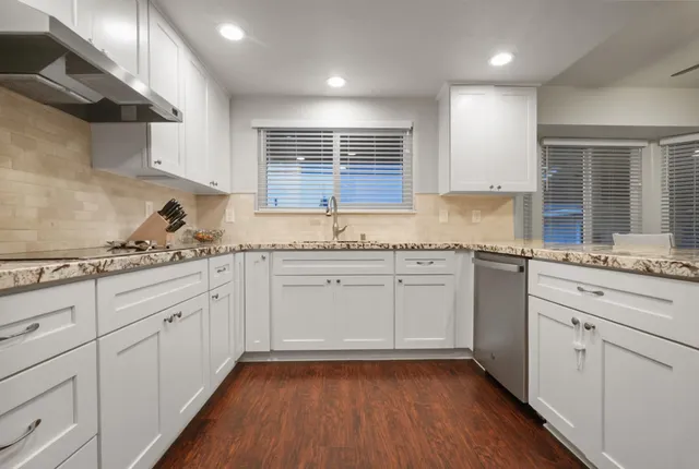 a kitchen with granite countertop stainless steel appliances a sink and cabinets
