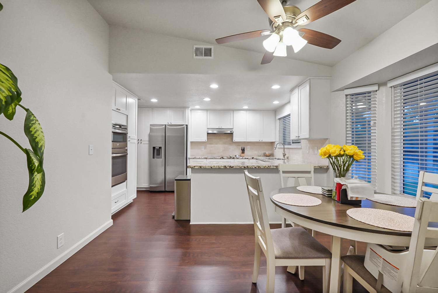1820 North Berkeley Avenue Turlock, CA 95382 - Photo 10 of 29 a kitchen with stainless steel appliances granite countertop a refrigerator a sink dishwasher a dining table and chairs with wooden floor