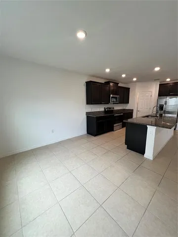 a large kitchen with a large counter top and stainless steel appliances