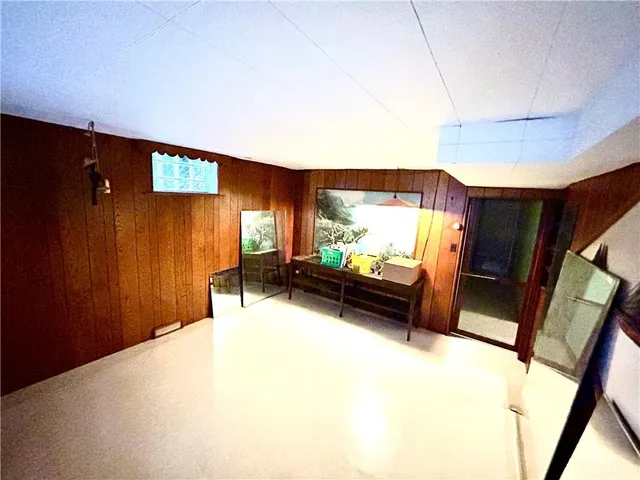 a bed sitting in a spacious bedroom next to a window and a bathroom