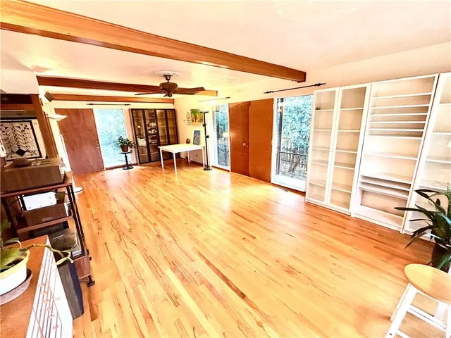 a view of a room with wooden floor and a potted plant