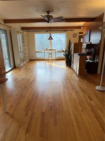 a kitchen with a refrigerator a stove and white cabinets with wooden floor