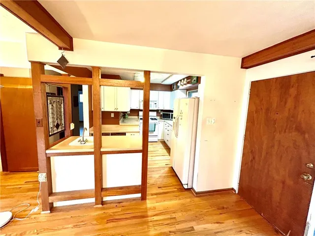 a view of a bedroom with a bed and wooden floor