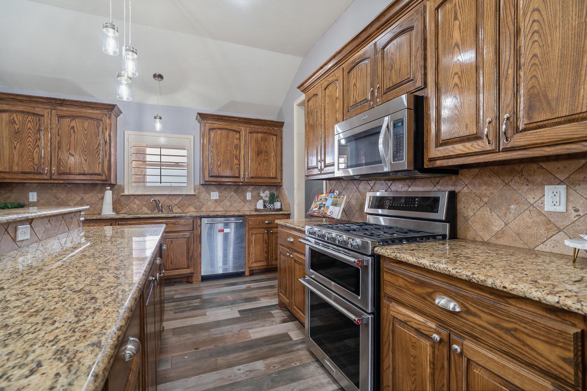 18451 Copper Ridge Bushland, TX 79124 - Photo 12 of 50 a kitchen with stainless steel appliances granite countertop a stove a sink and a microwave
