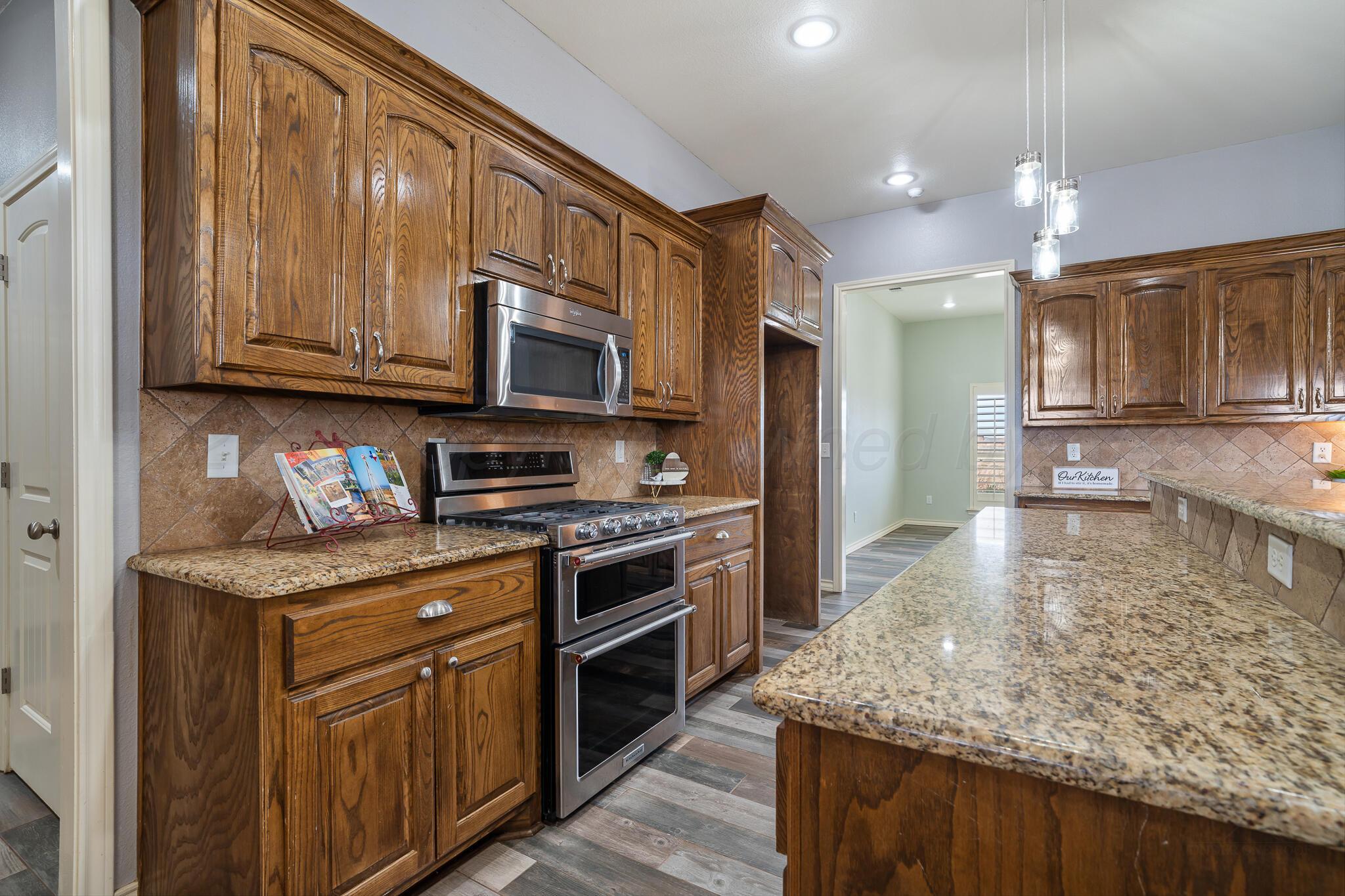 18451 Copper Ridge Bushland, TX 79124 - Photo 13 of 50 a kitchen with stainless steel appliances granite countertop a stove a sink and a microwave