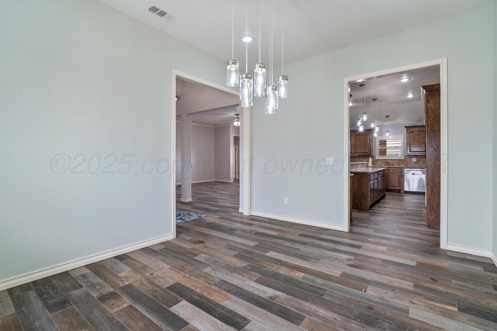 18451 Copper Ridge Bushland, TX 79124 - Photo 16 of 50 wooden floor in an empty room with kitchen view