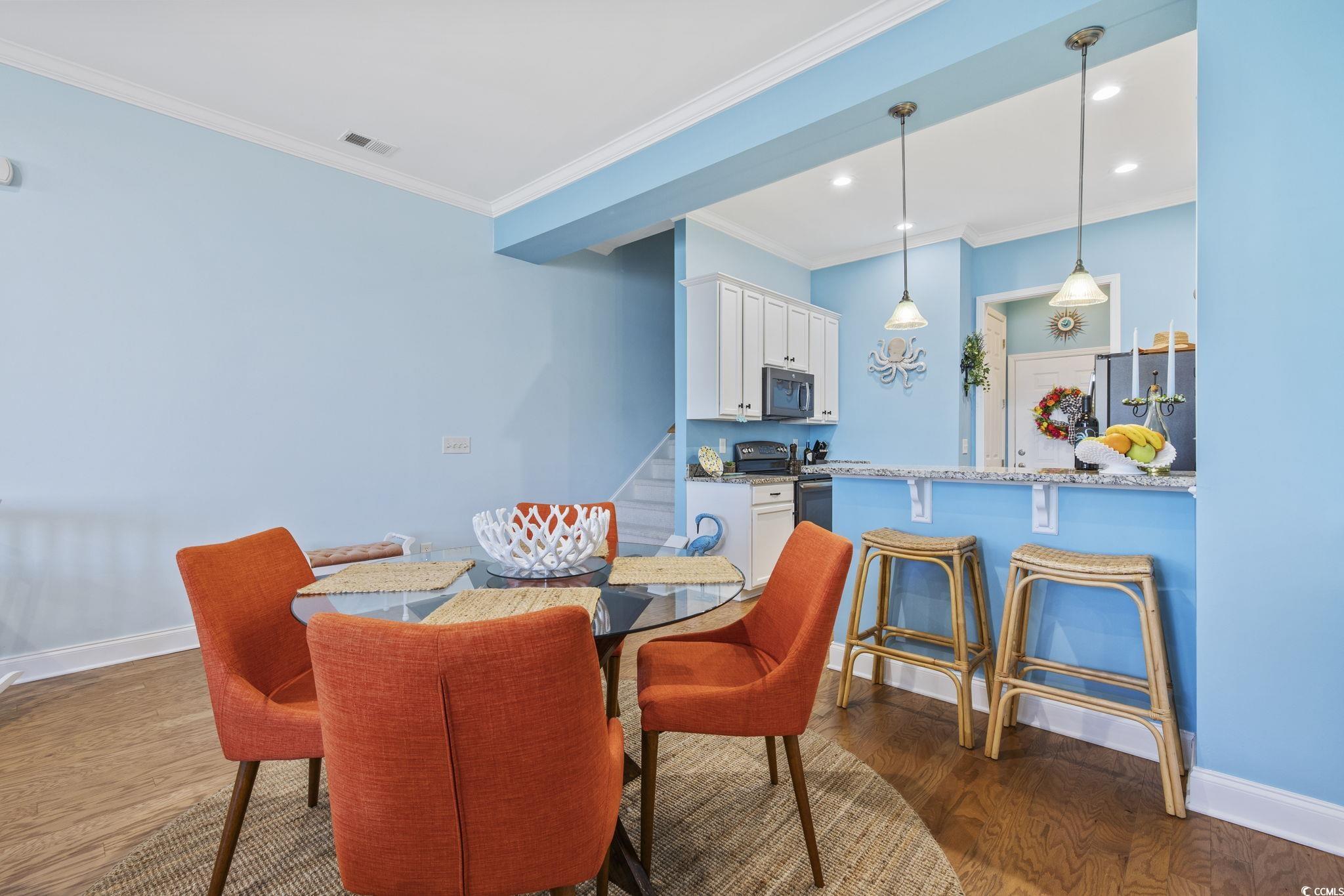 718 Shine Avenue, Unit 718 Myrtle Beach, SC 29577 - Photo 11 of 36 Dining area with dark wood finished floors, ornamental molding, and recessed lighting