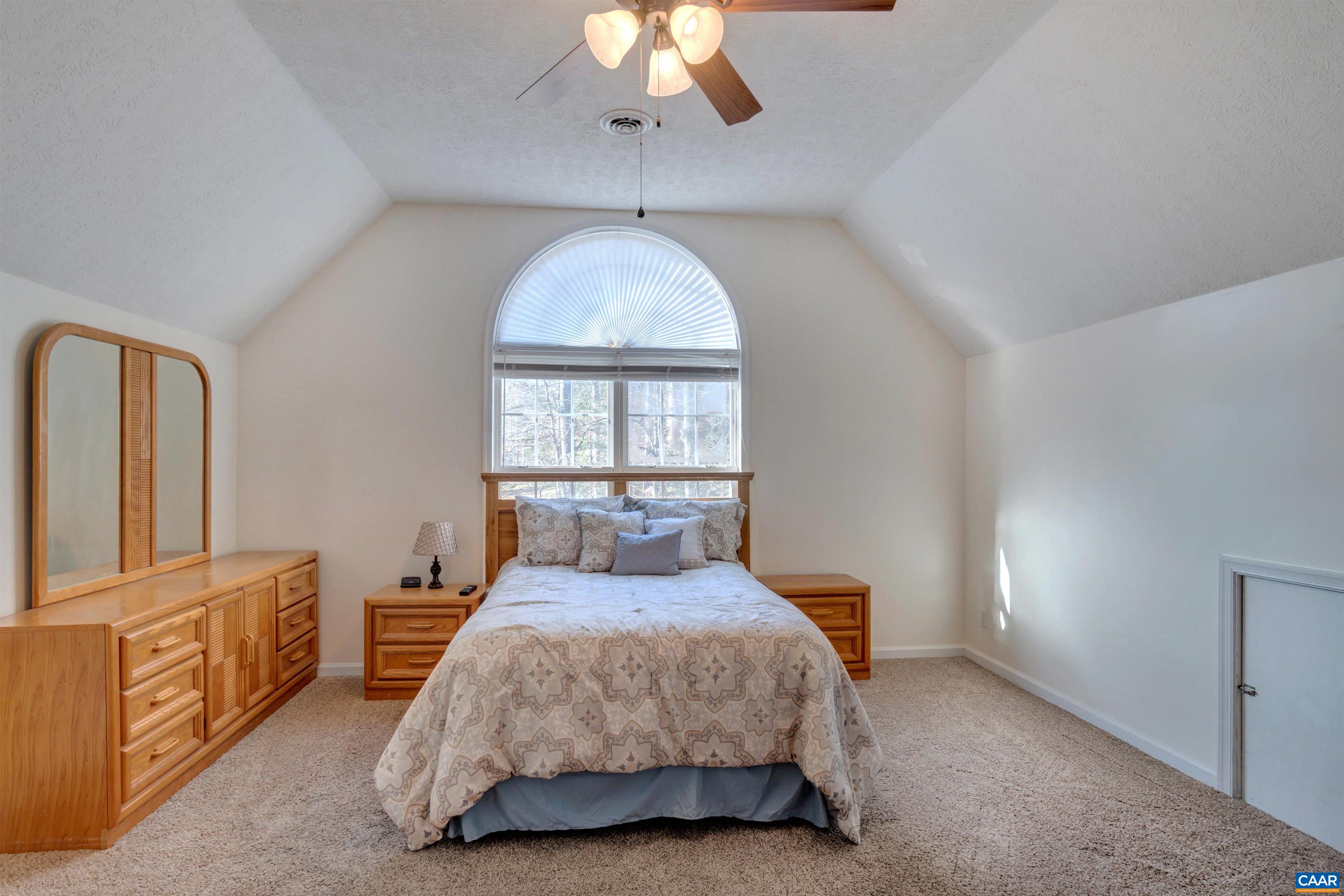 222 Starcrest Road Charlottesville, VA 22902 - Photo 31 of 46 a spacious bedroom with a bed and a chandelier