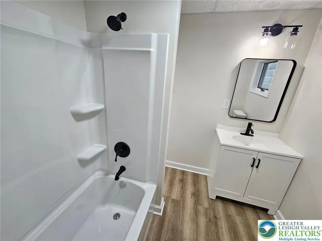 a bathroom with a sink a mirror and shower