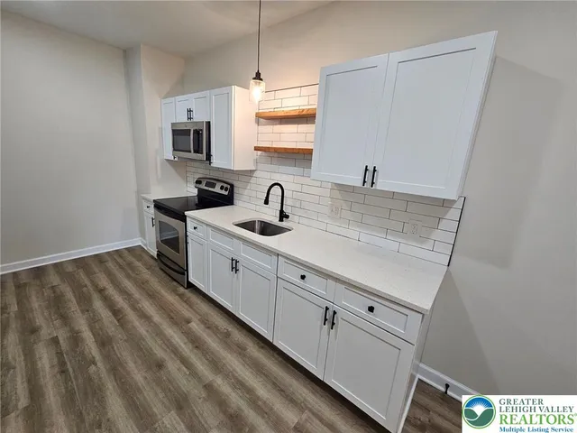 a kitchen with cabinets appliances and a sink