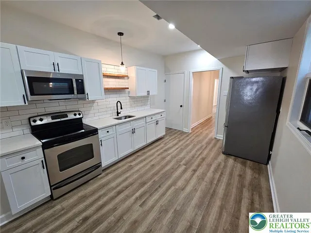 a kitchen with stainless steel appliances a stove a sink and a refrigerator