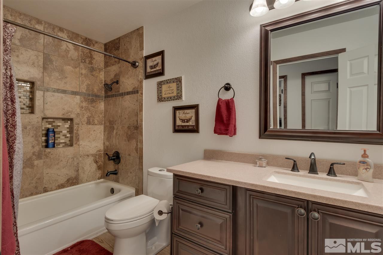 1661 Foster Drive Reno, NV 89509 - Photo 15 of 17 a bathroom with a sink vanity mirror bathtub and toilet