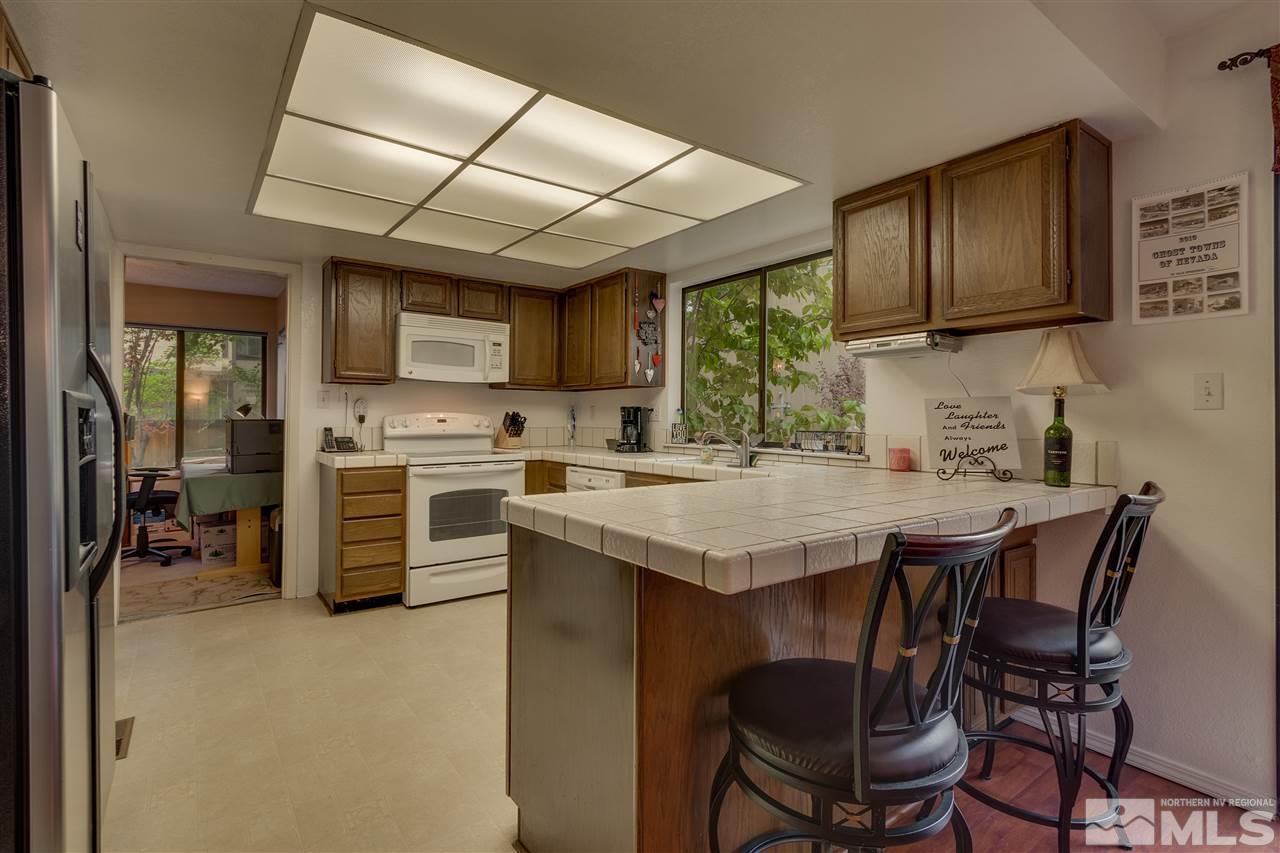 1661 Foster Drive Reno, NV 89509 - Photo 6 of 17 a kitchen with stainless steel appliances granite countertop a table chairs sink refrigerator and cabinets