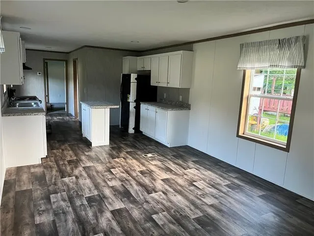 a view of a refrigerator in kitchen and a window