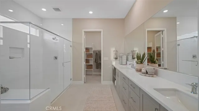 a bathroom with a double vanity sink mirror and shower