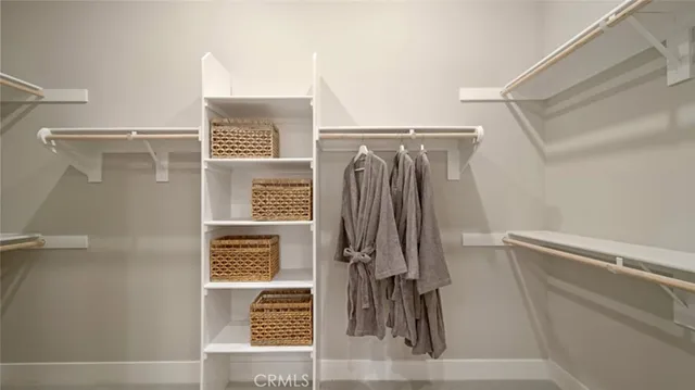 a view of walk in closet with clothes and shoes