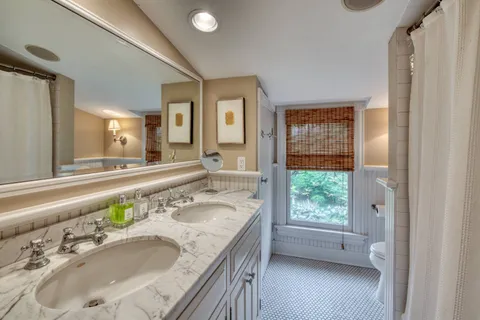 a bathroom with a granite countertop sink a mirror and a bathtub