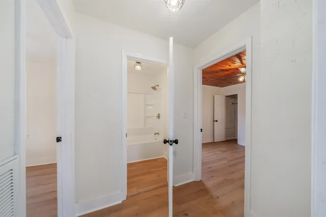a view of a hallway with wooden floor
