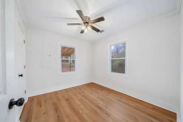 a view of a big room with wooden floor and windows