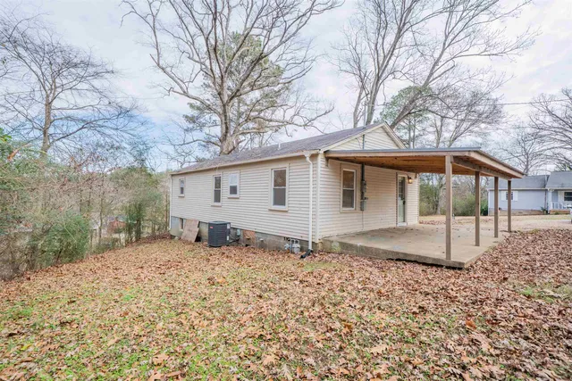 a view of a house with a yard and large tree